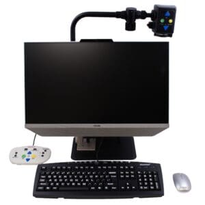 A desktop computer setup with monitor, keyboard, mouse, remote, and a camera mounted.