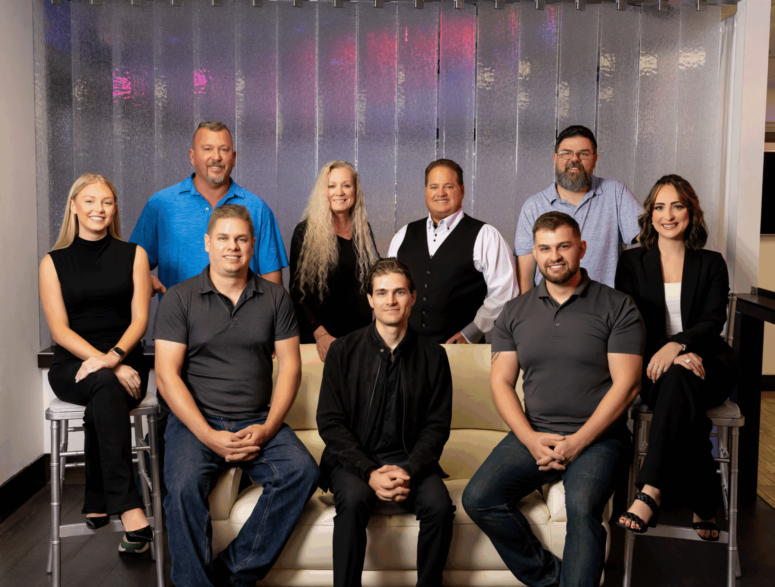 A group of ten professionals posing on stairs in a casual setting.